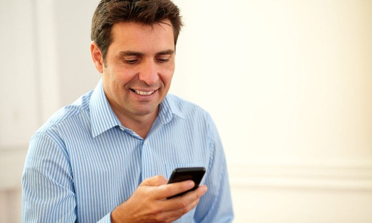 hispanic man texting on phone